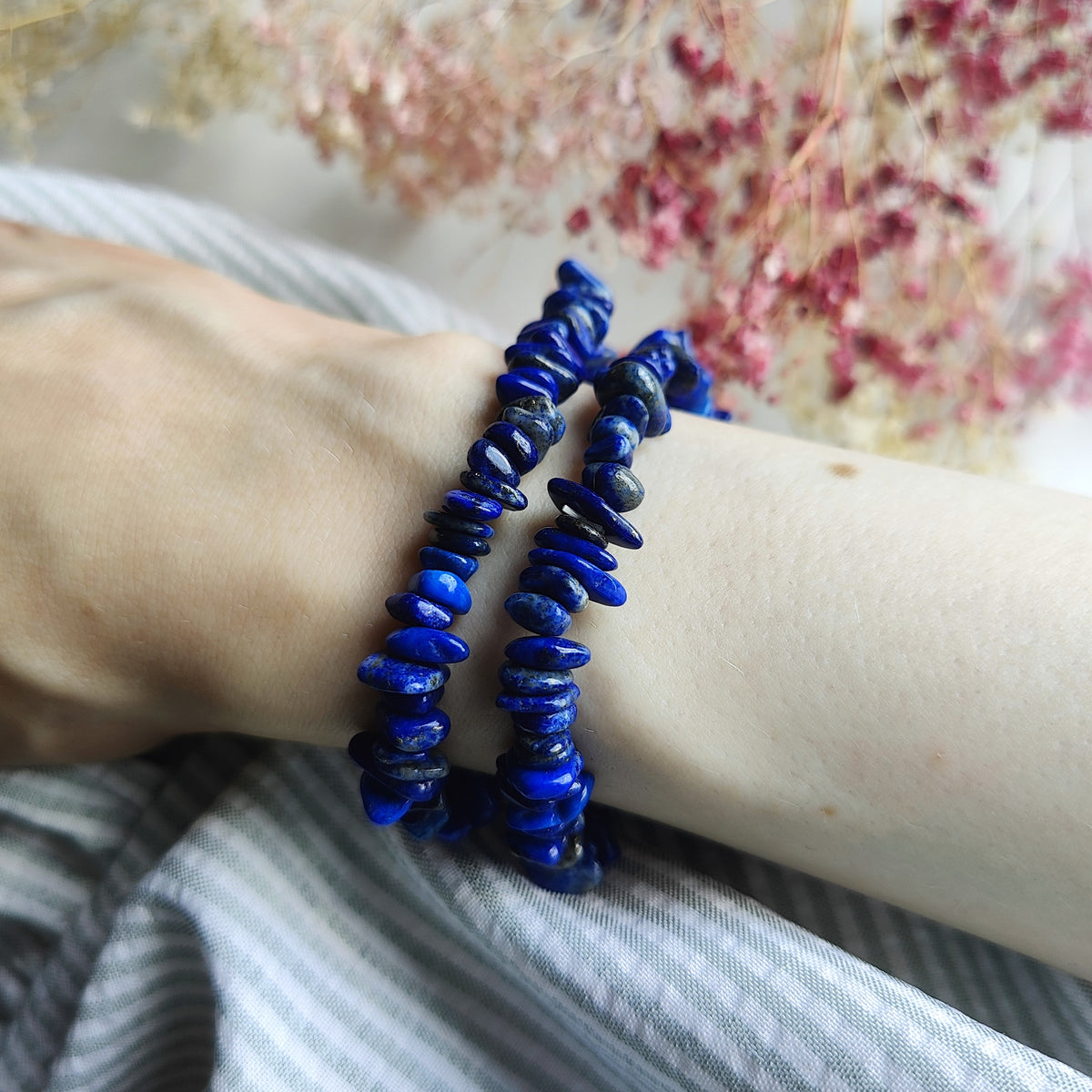 Siniset lapis lazuli hippurannekorut ranteessa