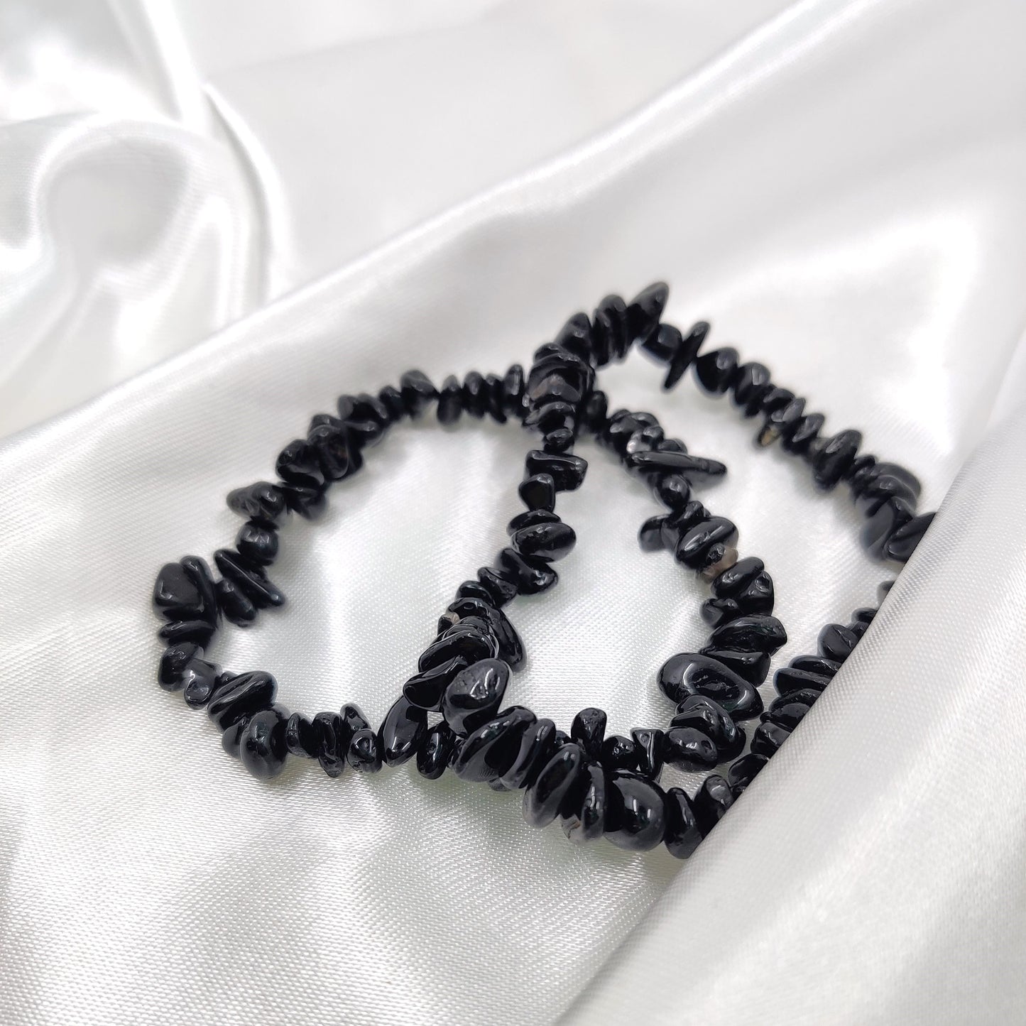 Musta turmaliini hippurannekoru valkoisella kankaalla