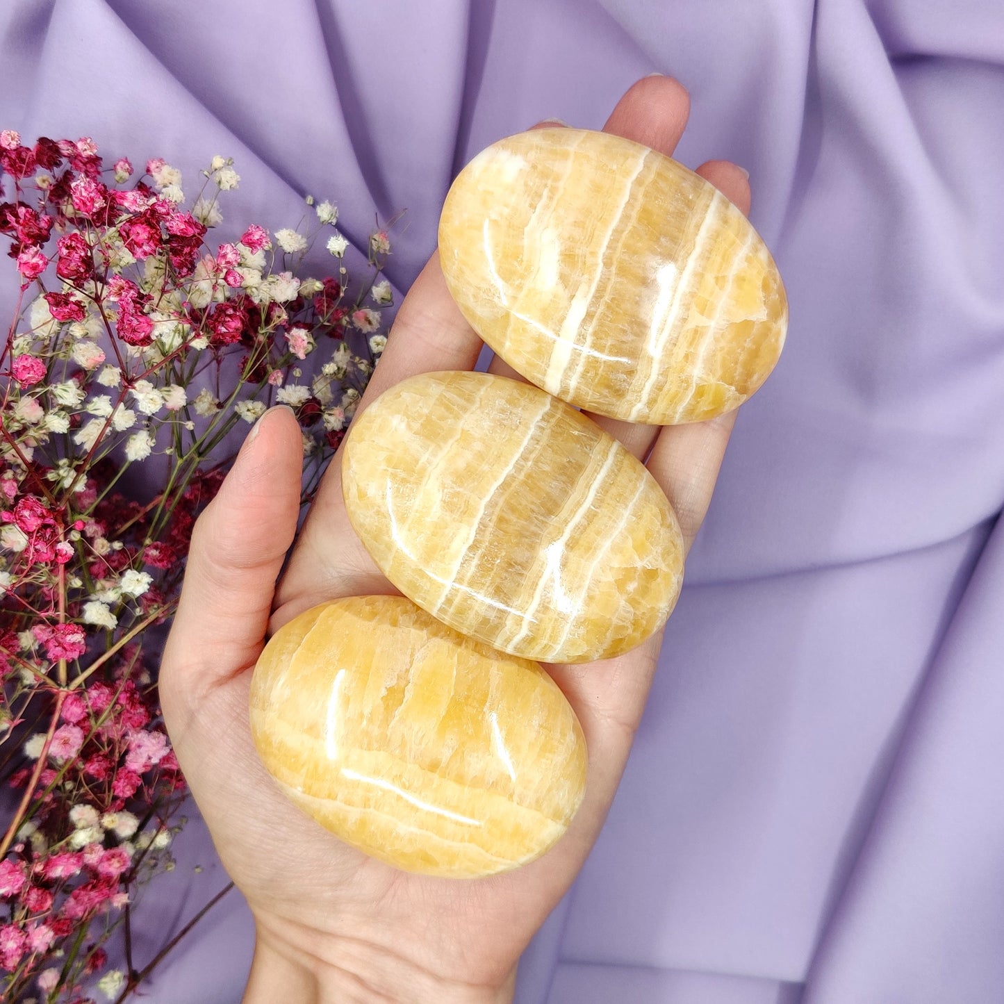 Raidallinen oranssi kalsiitti kämmenkivi