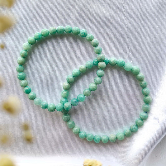 Vihreä amatsoniitti helmirannekoru valkoisella kankaalla