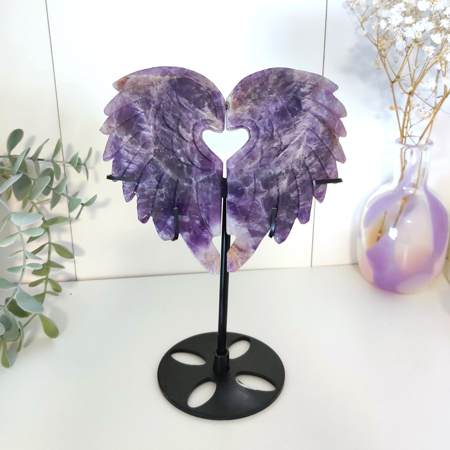 Syvän violettiset sydämen muotoiset  ametistisiivet telineessä hyllyssä