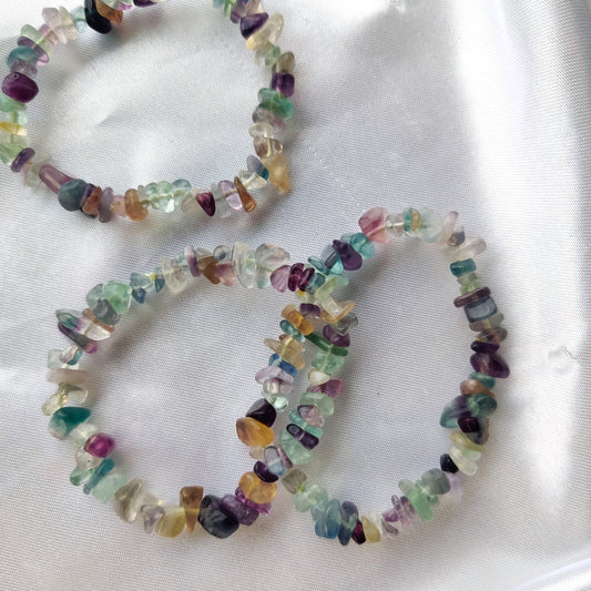 Värikkäät fluoriitti hippurannekorut valkoisella kankaalla