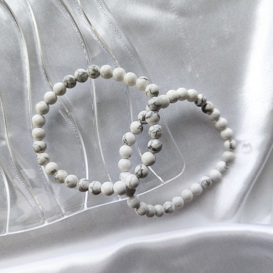 Howliitti helmirannekorut mustilla juovilla valkoisella taustalla