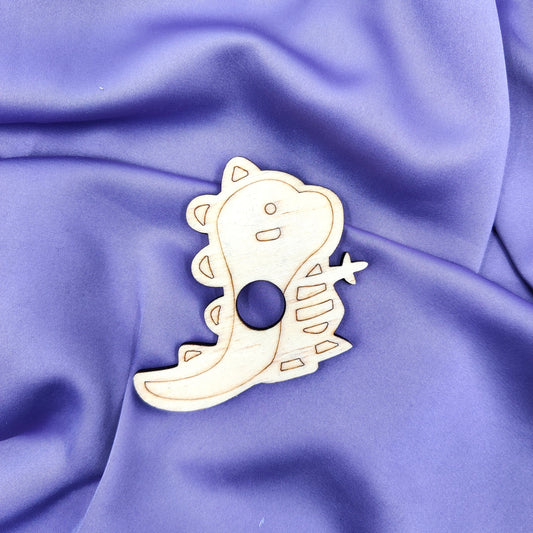 Laserleikattu ja kaiverrettu vanerinen dinosaurus-kivipalloalusta violetilla taustalla