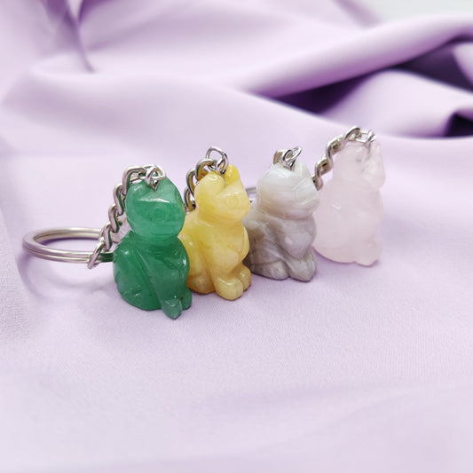 Vihreä aventuriini, keltainen kvartsi, akaatti ja ruusukvartsi kissa-aiheiset avaimenperät violetilla taustalla