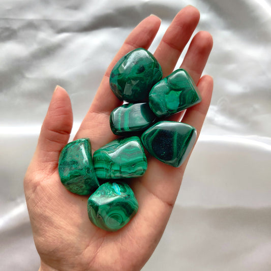 vihreitä hiottuja malakiitteja kädessä kuvattuna