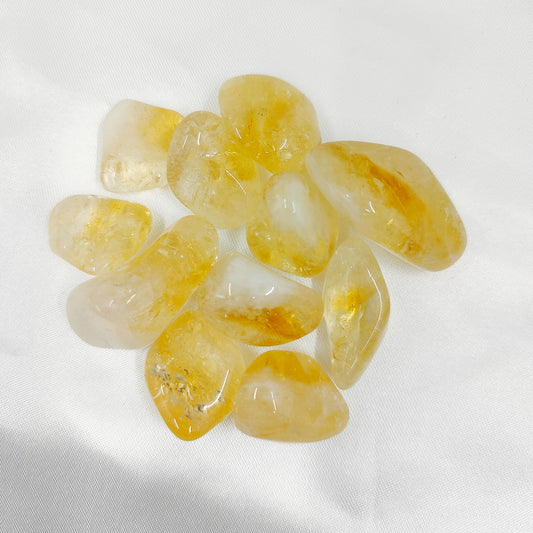 Keltaiset rumpuhiotut sitriinit valkoisella kankaalla