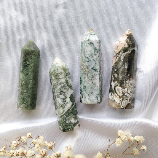 Vihreänvalkoiset sammalakaatti kivitornit valkoisella silkkikankaalla