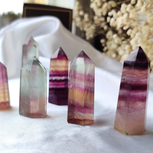 Kauniit fluoriitti kivitornit violetin eri sävyissä valkoisella silkkikankaalla