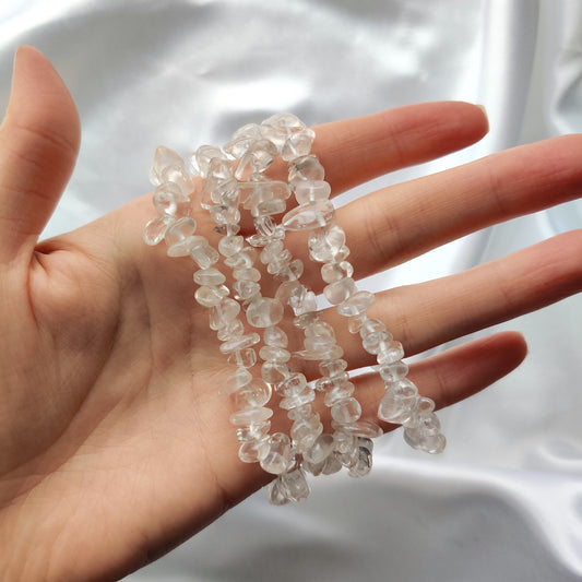 Vuorikristalli hippurannekoruja käden ympärillä  valkoisella taustalla