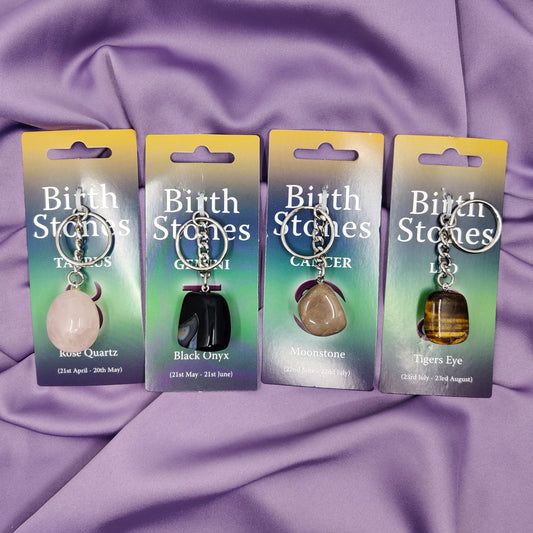 Härkä, kaksoset, rapu ja leijona-horoskooppiavaimenperät violetilla kankaalla.