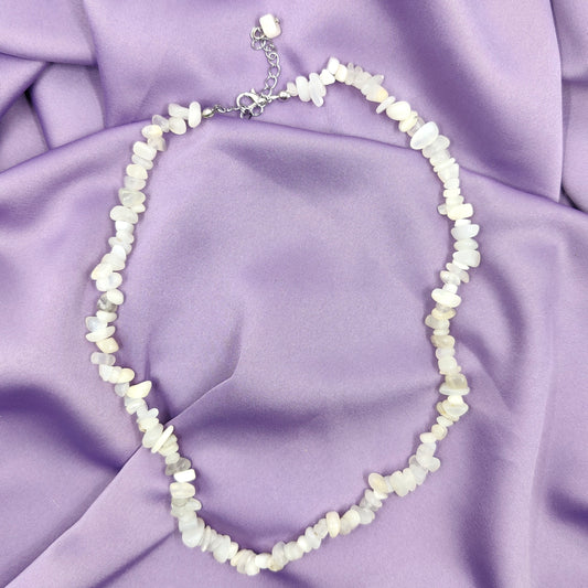 Säädettävä kuukivi hippukaulakoru hohtavine kuukivineen violetilla taustalla