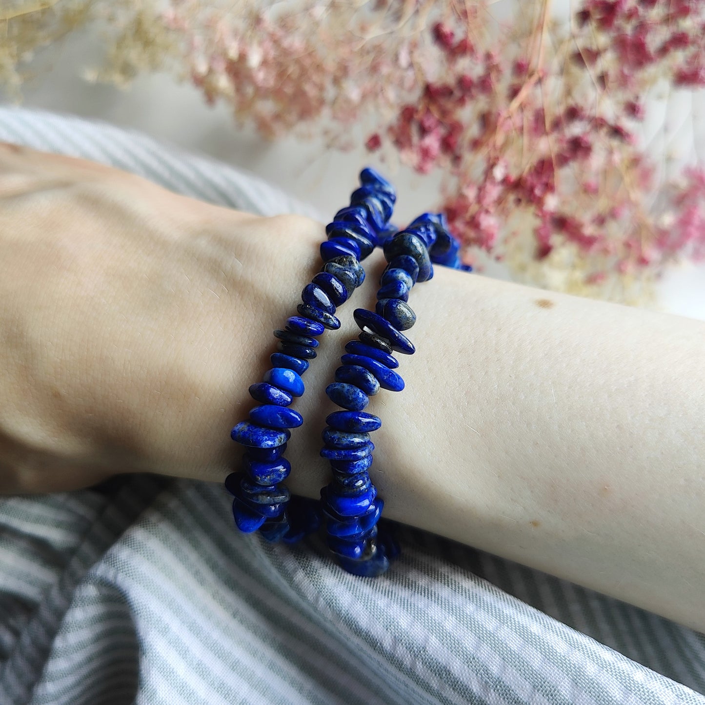Siniset lapis lazuli hippurannekorut ranteessa