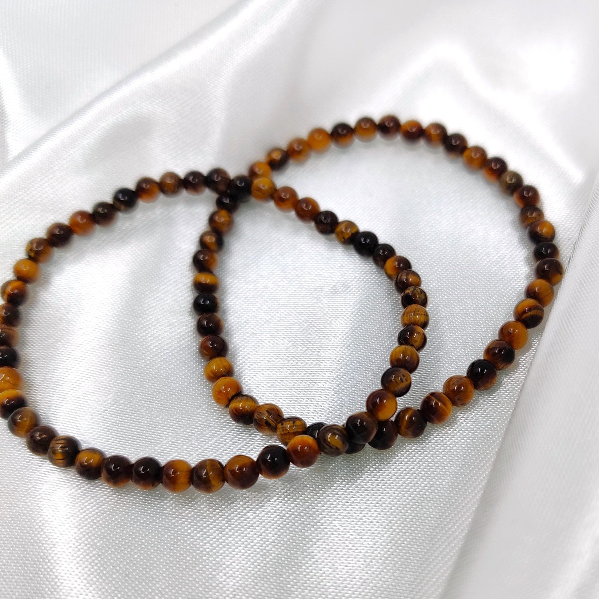 Ruskeat tiikerinsilmä helmirannekorut kuvattuna valkosella taustalla