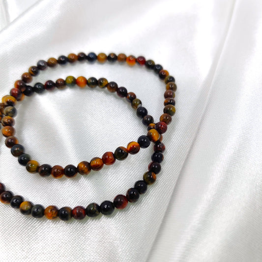 Tumman väriset tiikerinsilmä helmirannekorut valkoisella taustalla