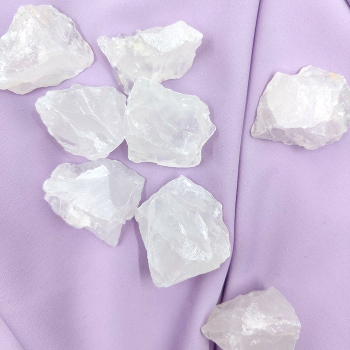 Vaaleat vuorikristalli raakapalat violetilla kankaalla